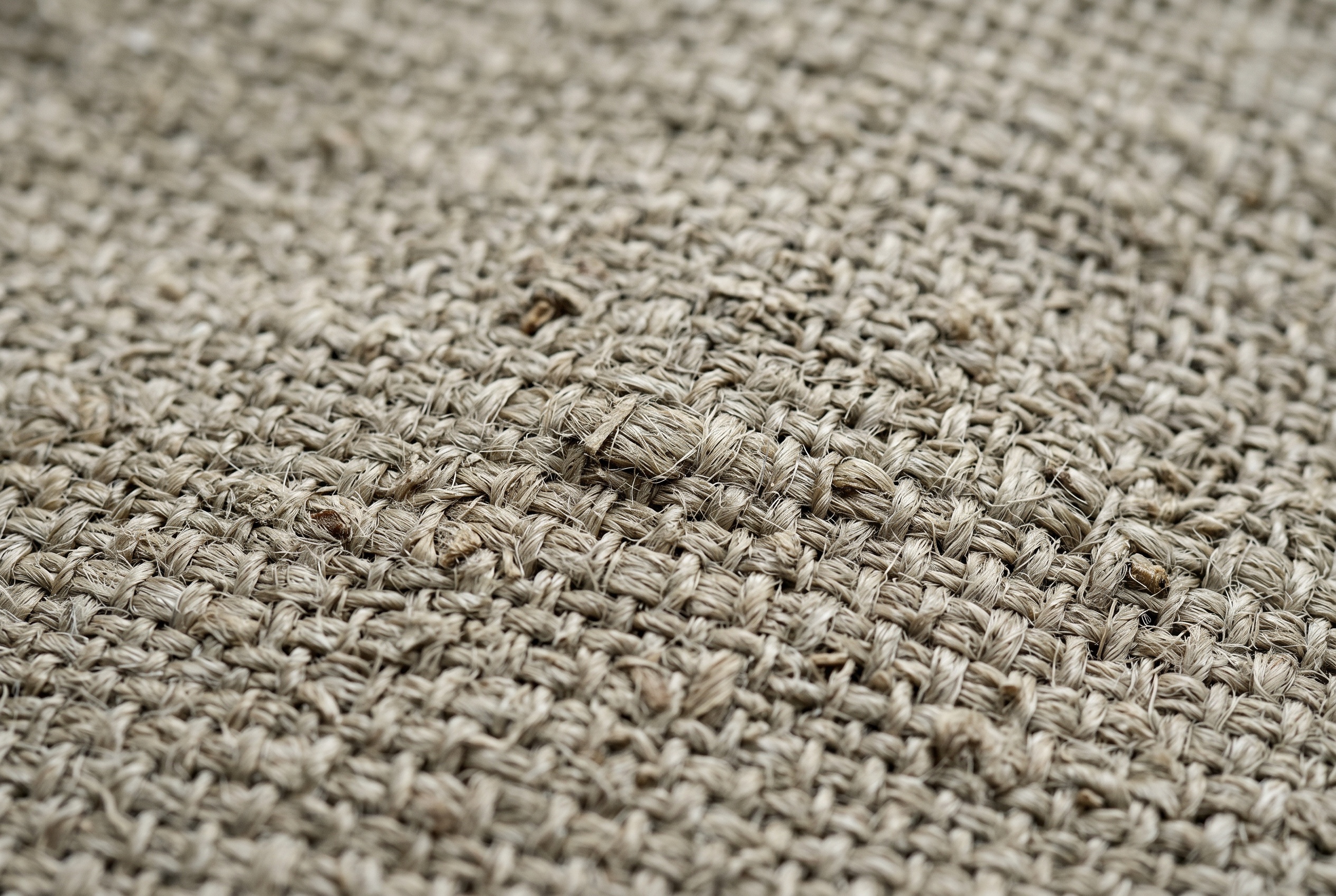 Macro of undyed hemp fabric showing a coarse natural weave