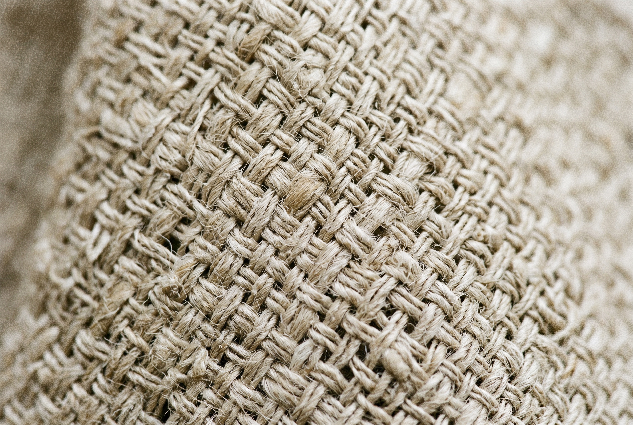 Macro of natural linen fabric showing slubby flax weave