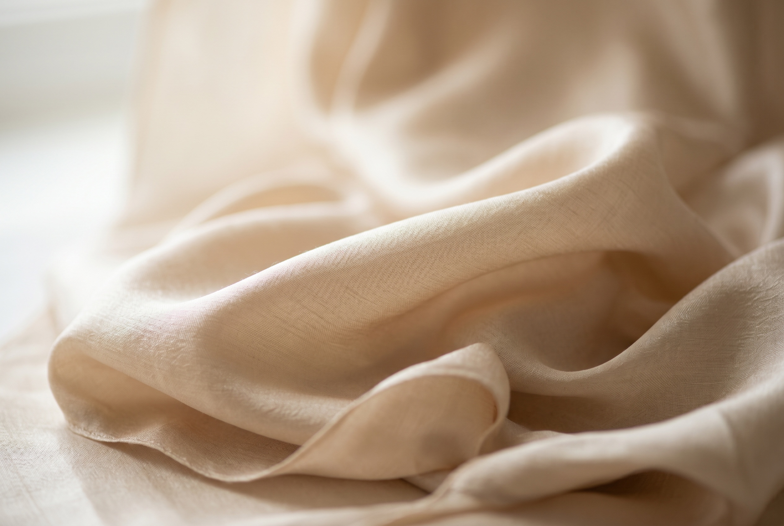 Macro of lustrous champagne silk fabric in soft folds